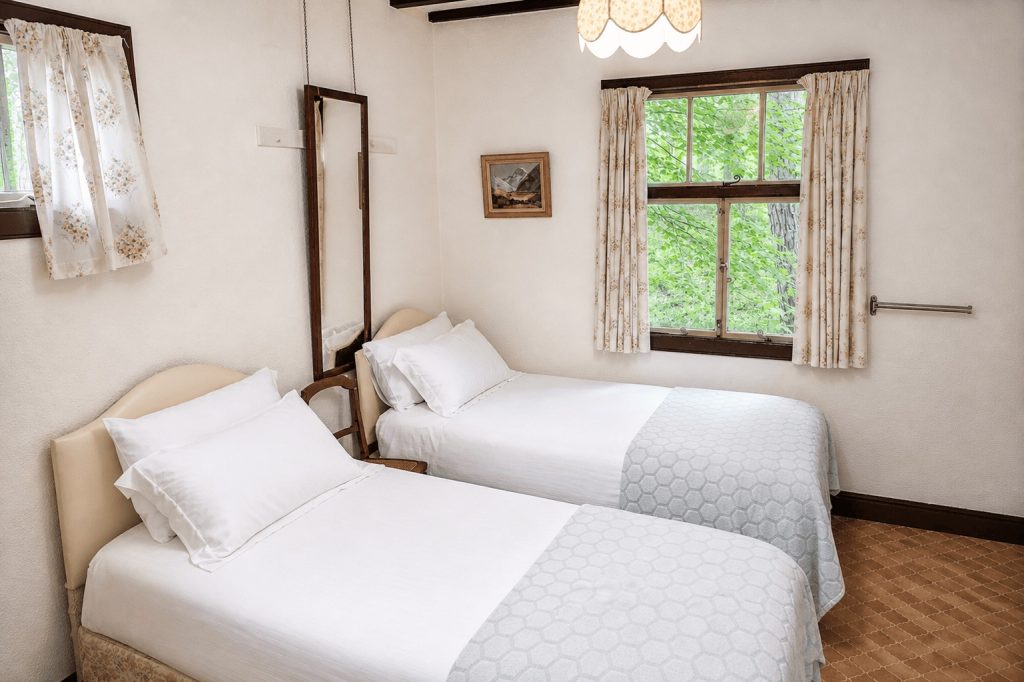 Twin bedroom with washbasin, overlooking private woodland at Windy Gap