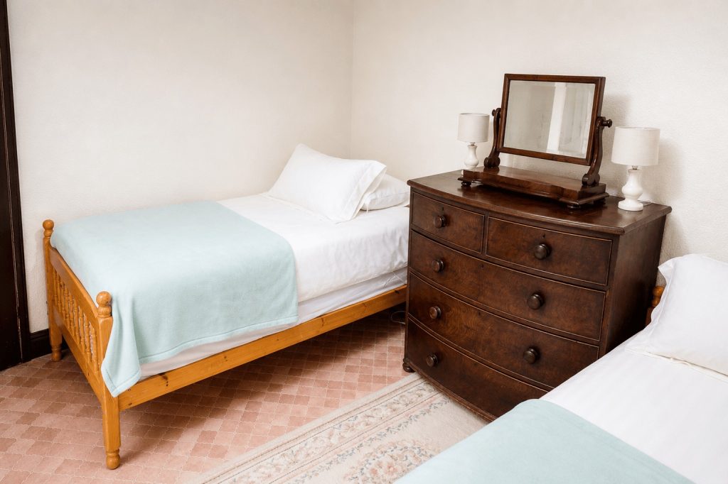 Twin bedroom with washbasin, overlooking lawn at Windy Gap